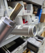 Load image into Gallery viewer, Metal fitting with a hexagonal head in a workshop setting