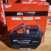Milwaukee M18 RedLithium Forge battery on a wooden surface with packaging in the background.